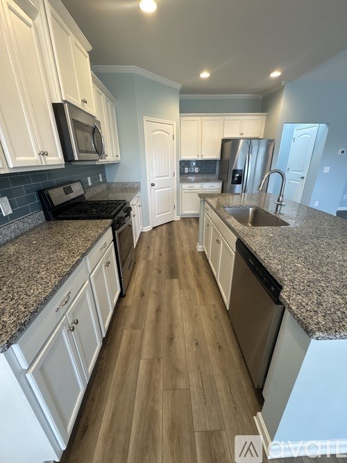 A kitchen with granite countertops and white cabinets.