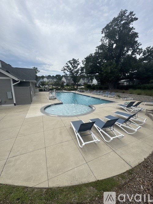 A pool with a few chairs around it.
