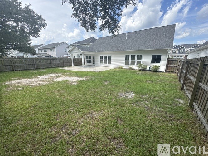 A backyard with a house and a fence.