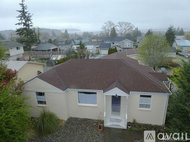 A house with a brown roof is surrounded by other houses.