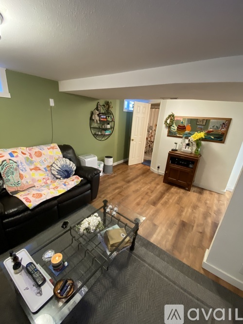 A living room with a couch, coffee table, and a painting on the wall.