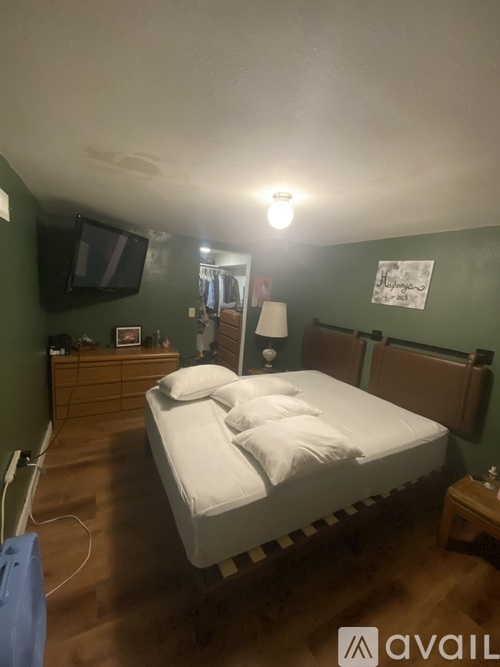 A bedroom with a bed, nightstand, and a television.