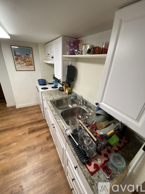 A kitchen with a sink and a picture on the wall.