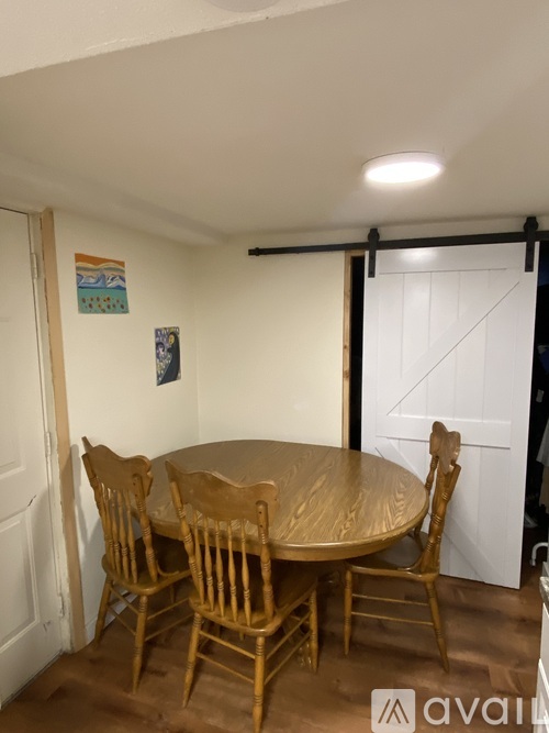 A dining room with a round table and chairs.