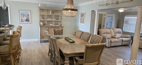 A kitchen with a stainless steel refrigerator and wooden floors.