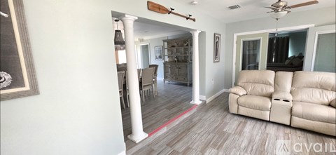 A dining room with a white table and chairs.
