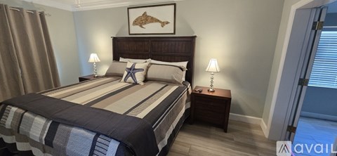 A bedroom with a bed, nightstand, and a ceiling fan.