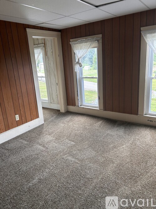 A room with brown wood paneling and carpet flooring.