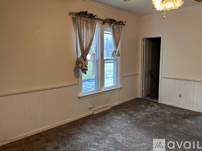 A room with a window and a door is available for rent.