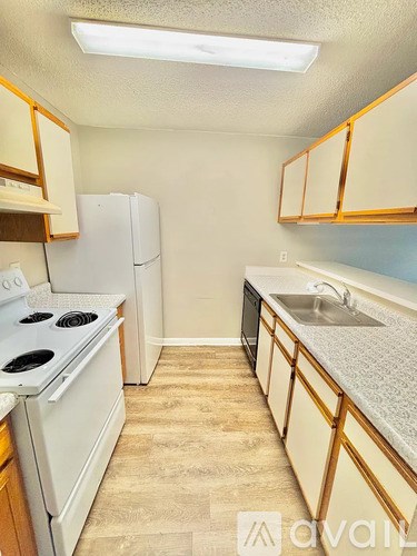 A kitchen with a white stove and a white refrigerator.