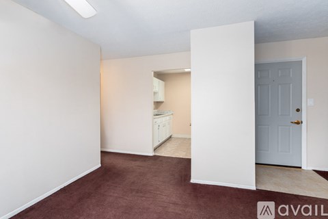 A room with a door and a carpeted floor.