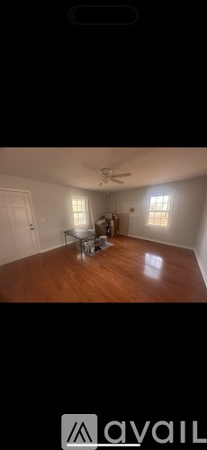 A room with a ceiling fan and a table with chairs.