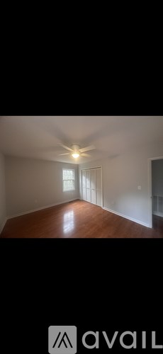 A room with a ceiling fan and a window.