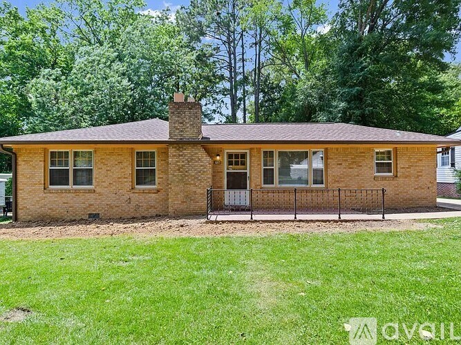 A brick house with a black iron fence in front.