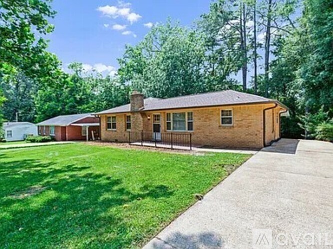 A house with a brown roof and a green lawn in front.