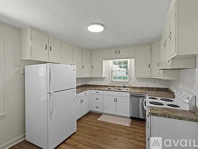 A kitchen with white appliances and cabinets.