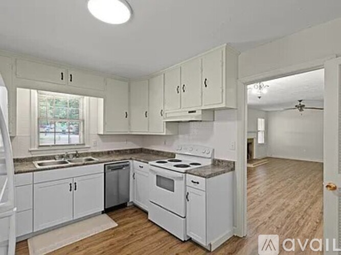 A kitchen with white cabinets and appliances.
