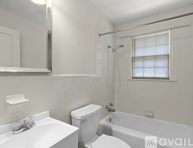 A white bathroom with a toilet, sink, and bathtub.
