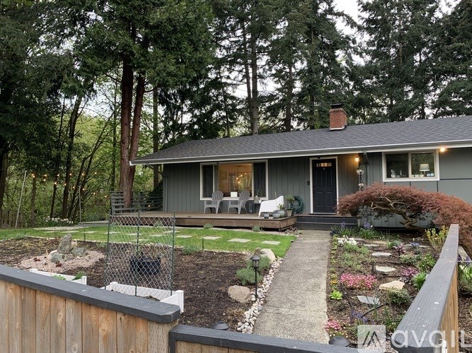 A house with a grey roof and a garden in front.