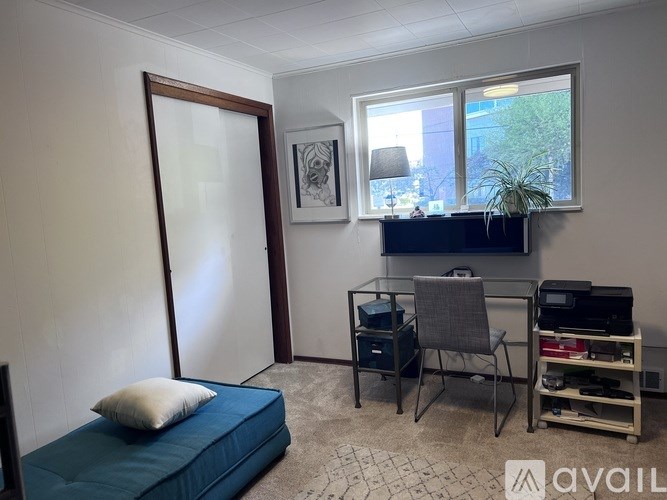 A room with a bed, desk, and chair.