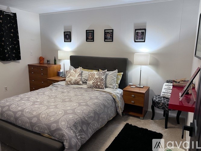 A bedroom with a bed, nightstand, and chair.