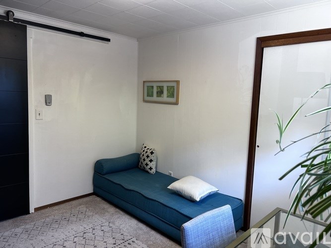 A room with a blue couch and a picture on the wall.