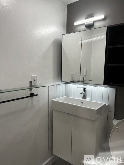 A white sink in a bathroom with a mirror above it.
