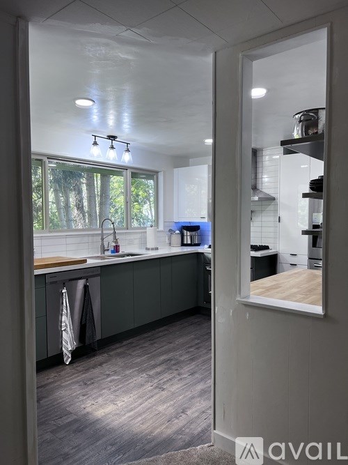 A kitchen with a window and a view of trees outside.