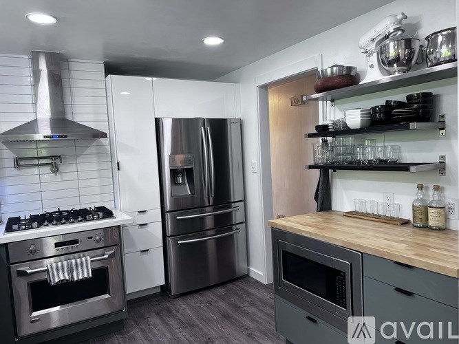 A modern kitchen with stainless steel appliances and wooden countertops.