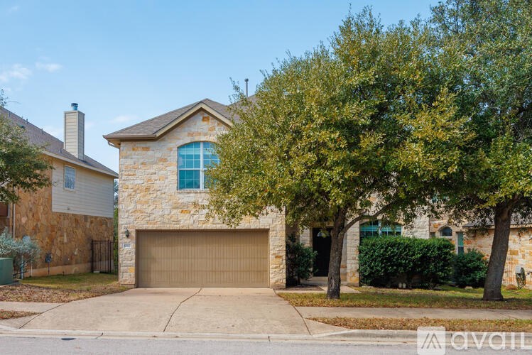 A house with a stone facade and a brown garage door.