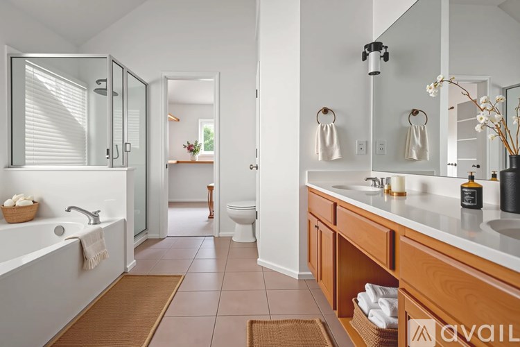 A bathroom with a white tub and a brown rug.