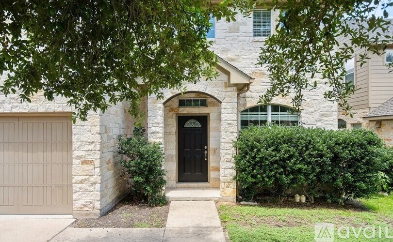 A house with a black door and a stone wall.