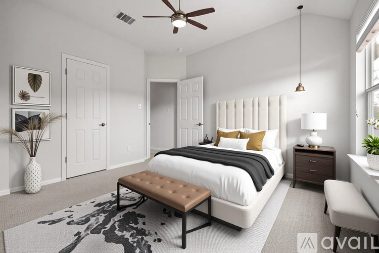 A bedroom with a bed, chair, and a ceiling fan.