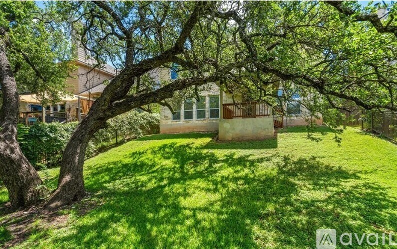 A tree in front of a house with a sign that says "avart".