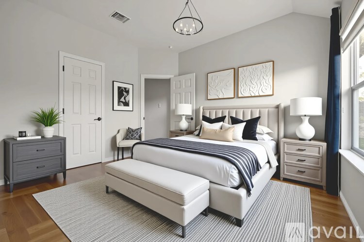 A bedroom with a large bed, two nightstands, and a plant.