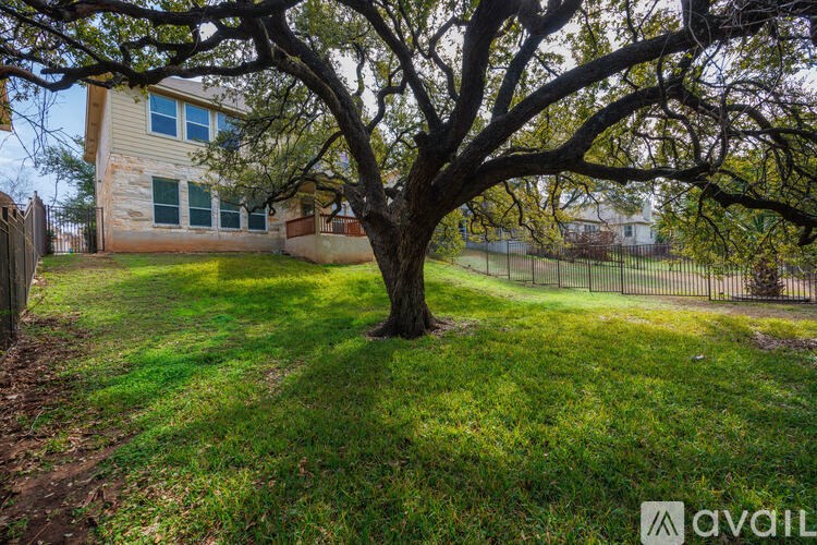A tree in a yard in front of a house.