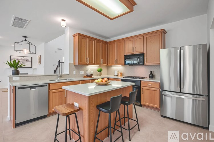 A kitchen with wooden cabinets and a white island.