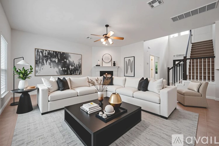 A living room with a white couch, a coffee table, and a ceiling fan.