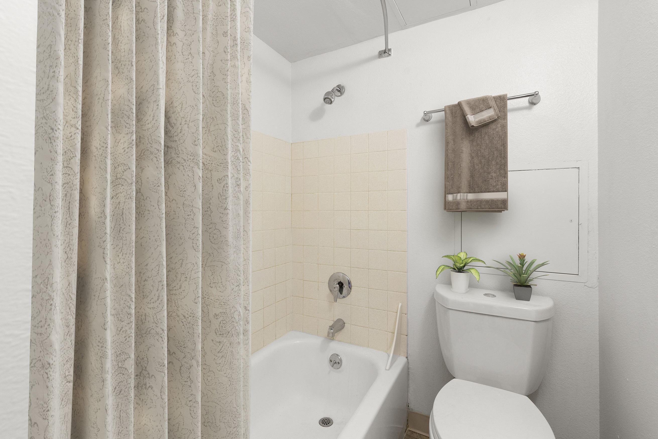 a bathroom with a toilet and a tub and a shower curtain