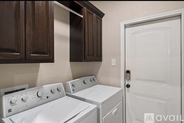 A white washing machine and dryer in a laundry room.