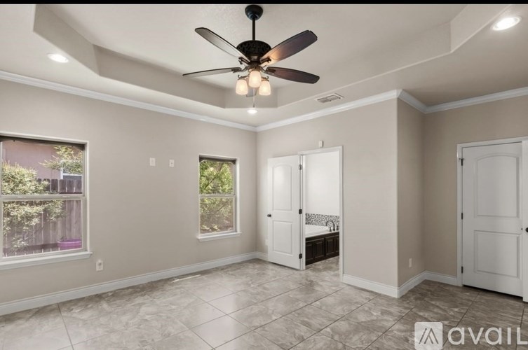 A room with a ceiling fan and tiled flooring.
