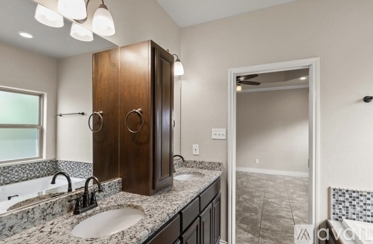A bathroom with a marble countertop and a double sink vanity.