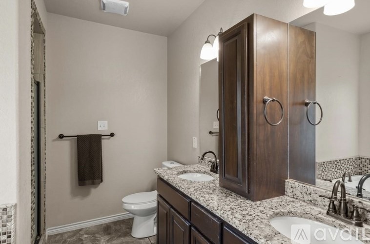 A bathroom with a toilet, sink, and a large mirror.