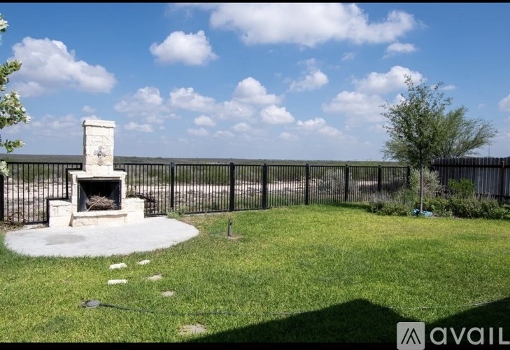 A backyard with a fireplace and a fence.