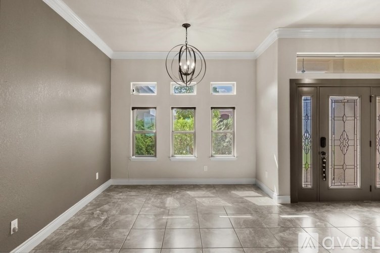 A room with a grey wall and a brown door.