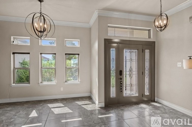 A foyer with a marble floor and a double door with a glass panel.