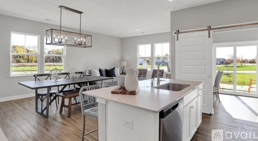 A kitchen with white appliances and a dining table with chairs.