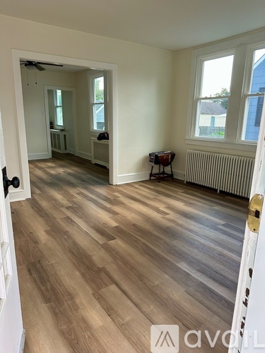 A room with wooden flooring and white walls.