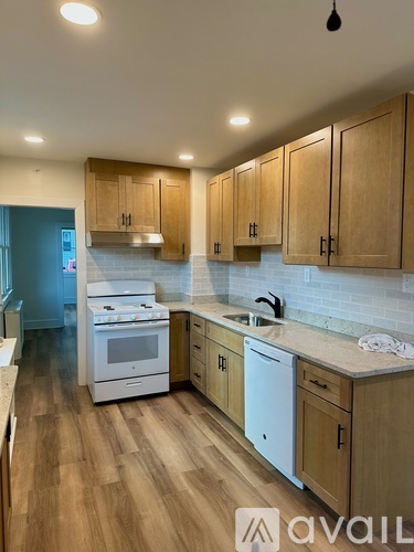 A kitchen with wooden cabinets and a white dishwasher.