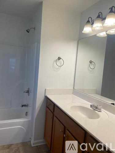 A bathroom with a white sink and a white tub.